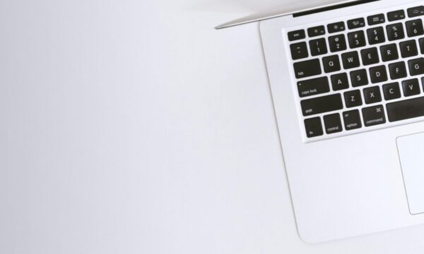 Free Aerial view of a sleek laptop keyboard on a clean, white surface, ideal for tech backgrounds. Stock Photo